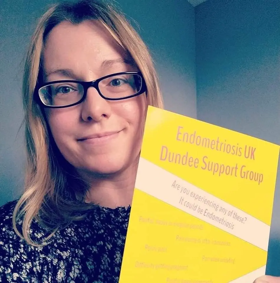 Photo de Vicky tenant une affiche du "Endometriosis UK Dundee Support Group" (groupe de soutien d'Endometriosis UK Dundee)