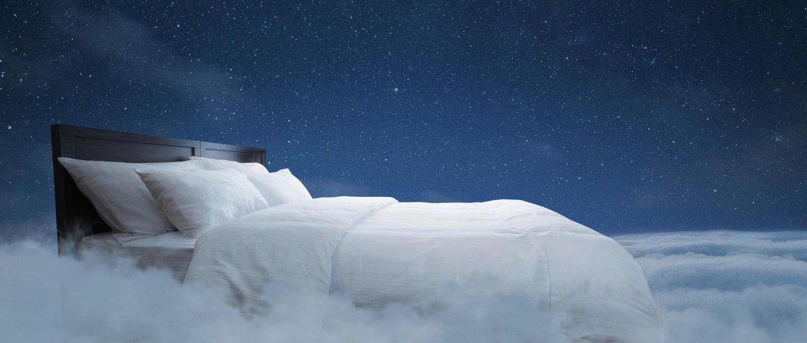 Lit avec des oreillers et une couverture vole dans les nuages avec un ciel étoilé de nuit avec la lune, idée créative. Doux rêve, concept. Repos nocturne