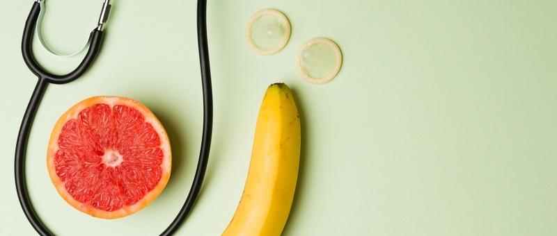 Stéthoscope avec tranche de pamplemousse et banane sur fond vert.