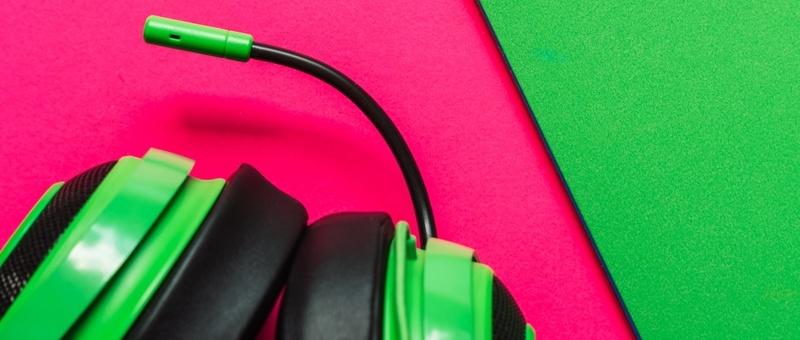 Casque de jeu avec micro sur fond rose et vert.