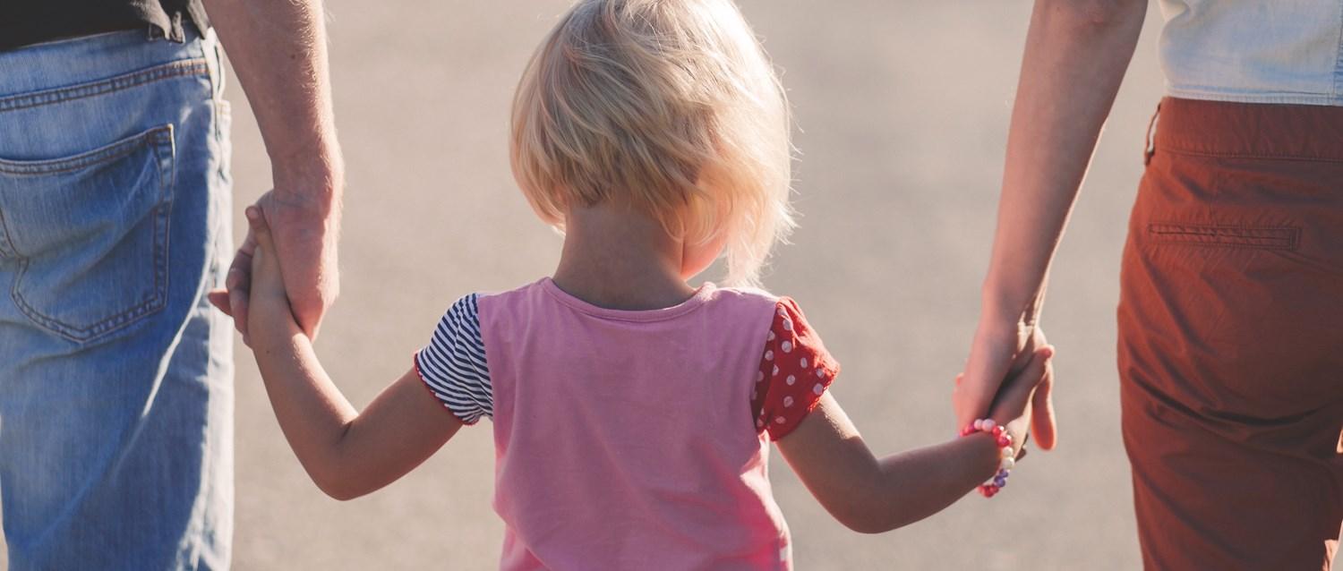 Enfant tenant la main de ses parents