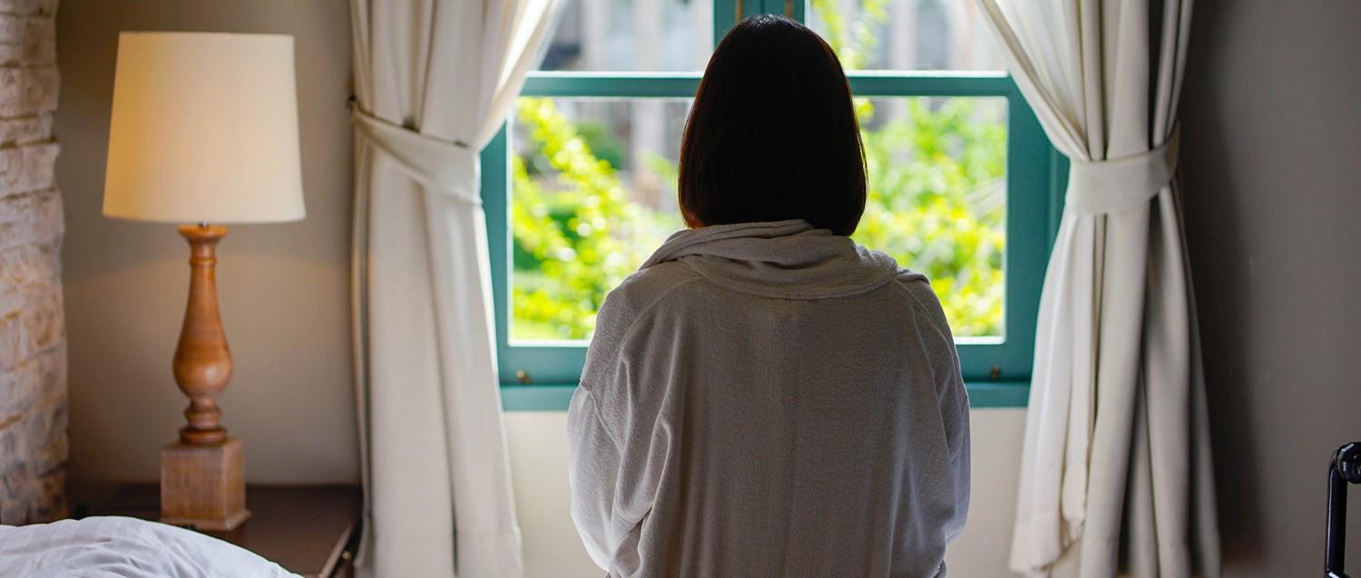 femme triste regardant par la fenêtre
