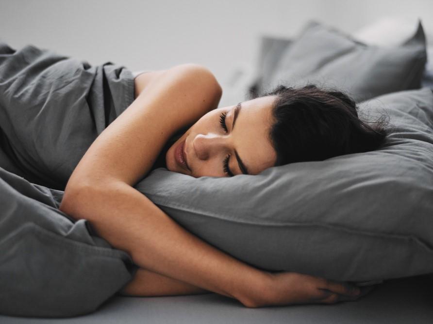 femme dormant dans un lit gris